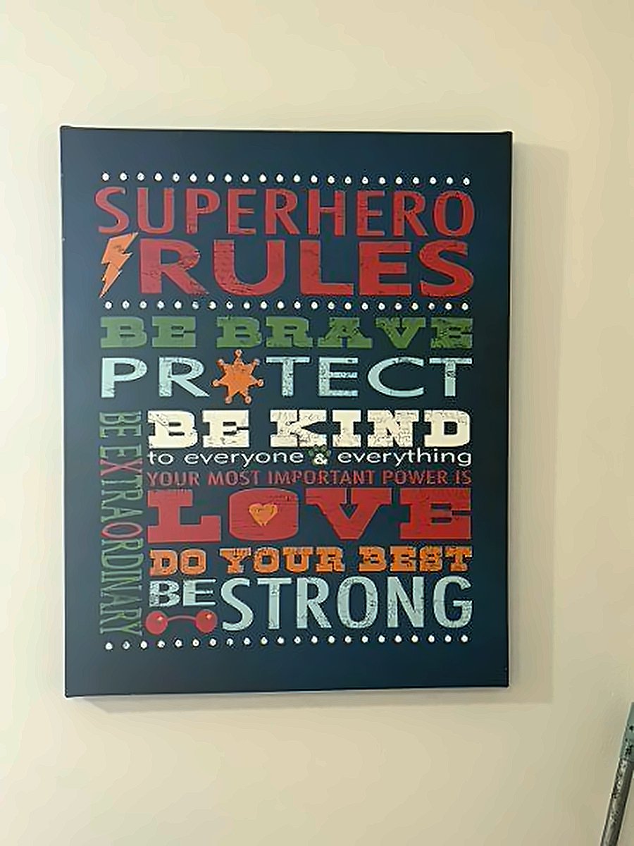 Wall sign reading Superhero Rules: be brave, protect, be kind, love, do your best, be strong