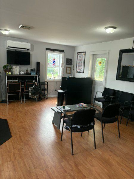 Waiting area with chairs, a coffee table and a wall-mounted TV